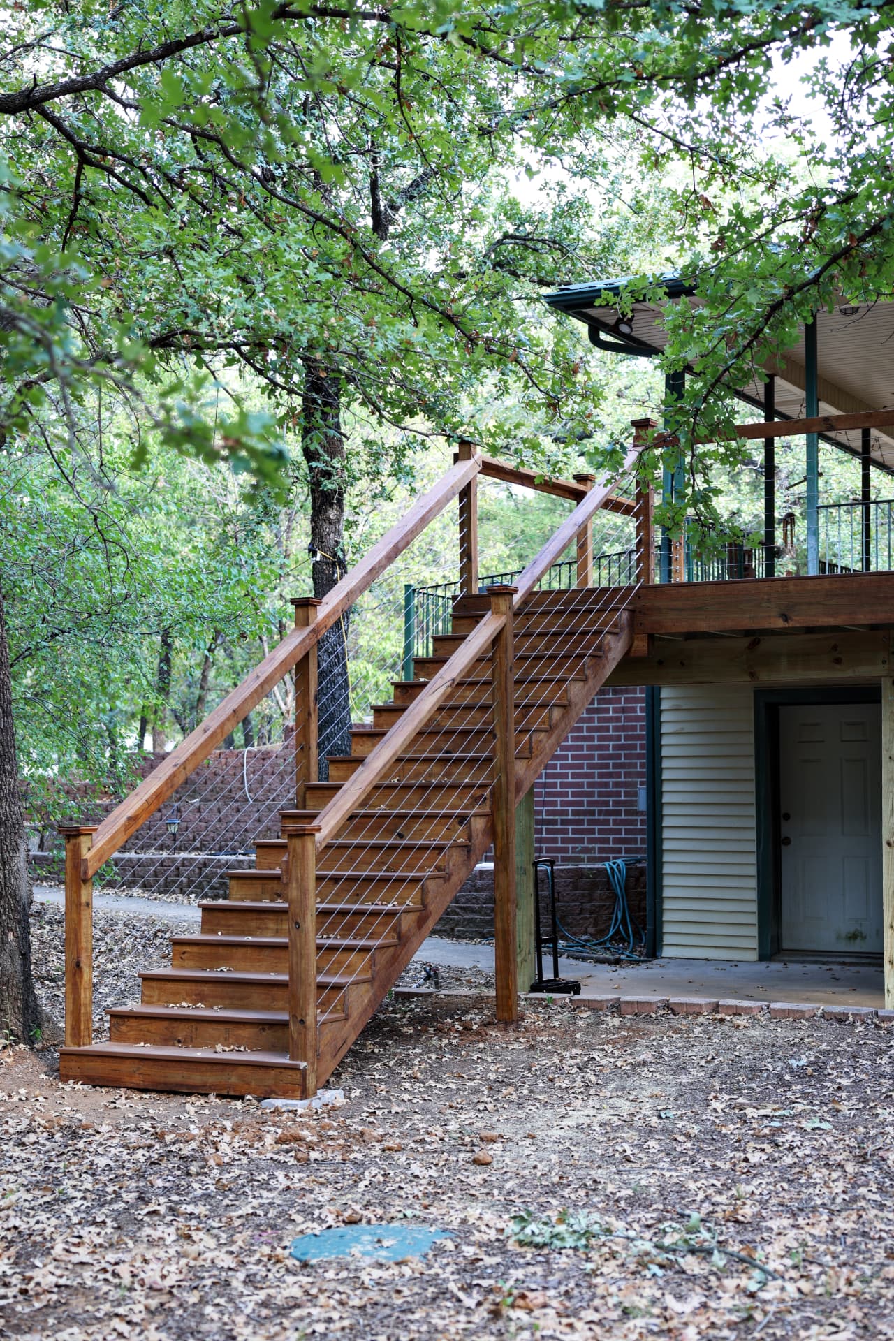 Elevated cedar deck with cable rail stairway down to the yard