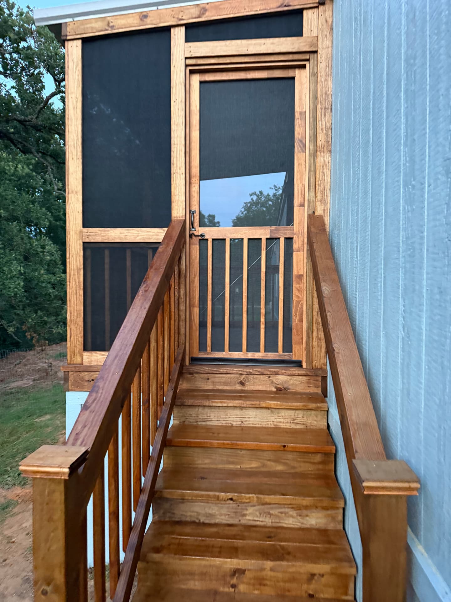 Stained screened porch with screen door and stairway