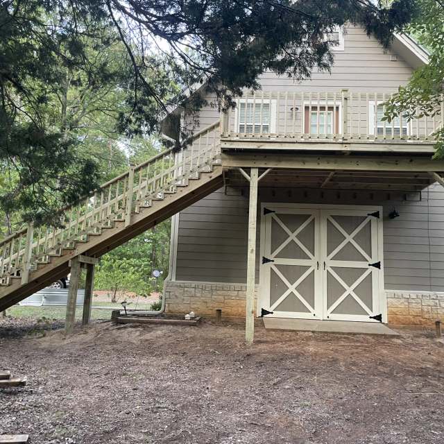 Elevated second-story pressure-treated deck with railing and long stairway built by BenchMark Decks