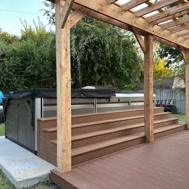 Wide composite steps up to a pool spa under a cedar pergola