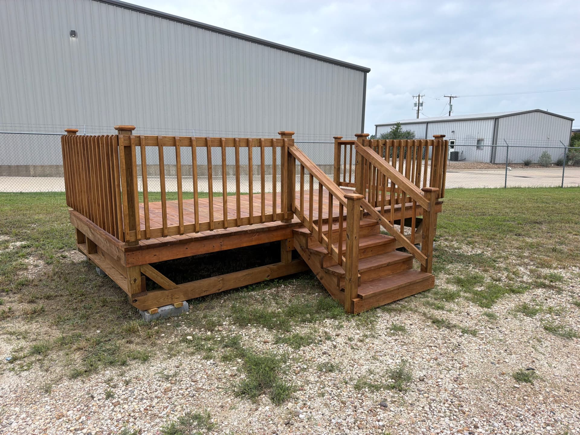 Stained treated wood deck with privacy wall, railing and steps