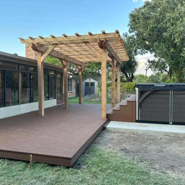 Composite deck and cedar pergola next to a pool spa
