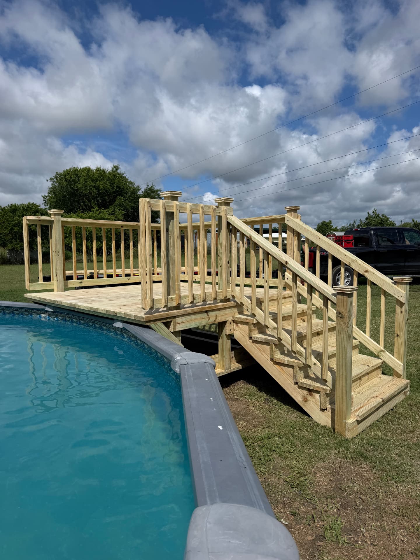 Treated wood pool landing deck with railing and stairway