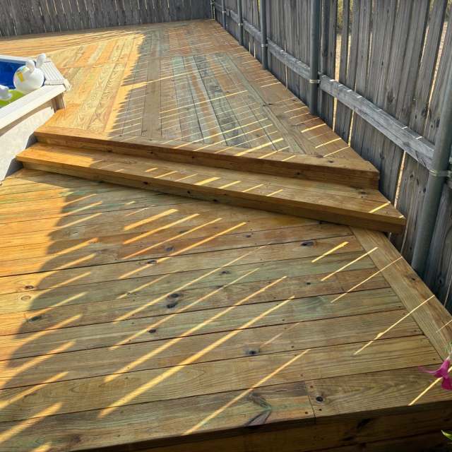 Two-level stained pool deck with angled steps along the fence