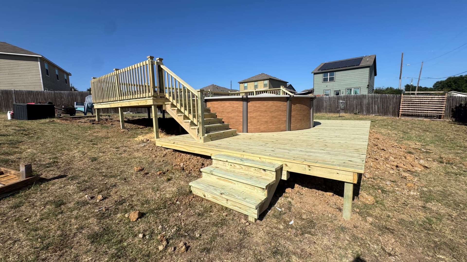 Two-level backyard deck with stairs beside an above-ground pool