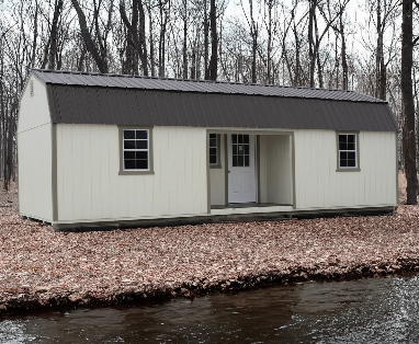 Cream lofted barn cabin shed with dark metal roof and covered front porch