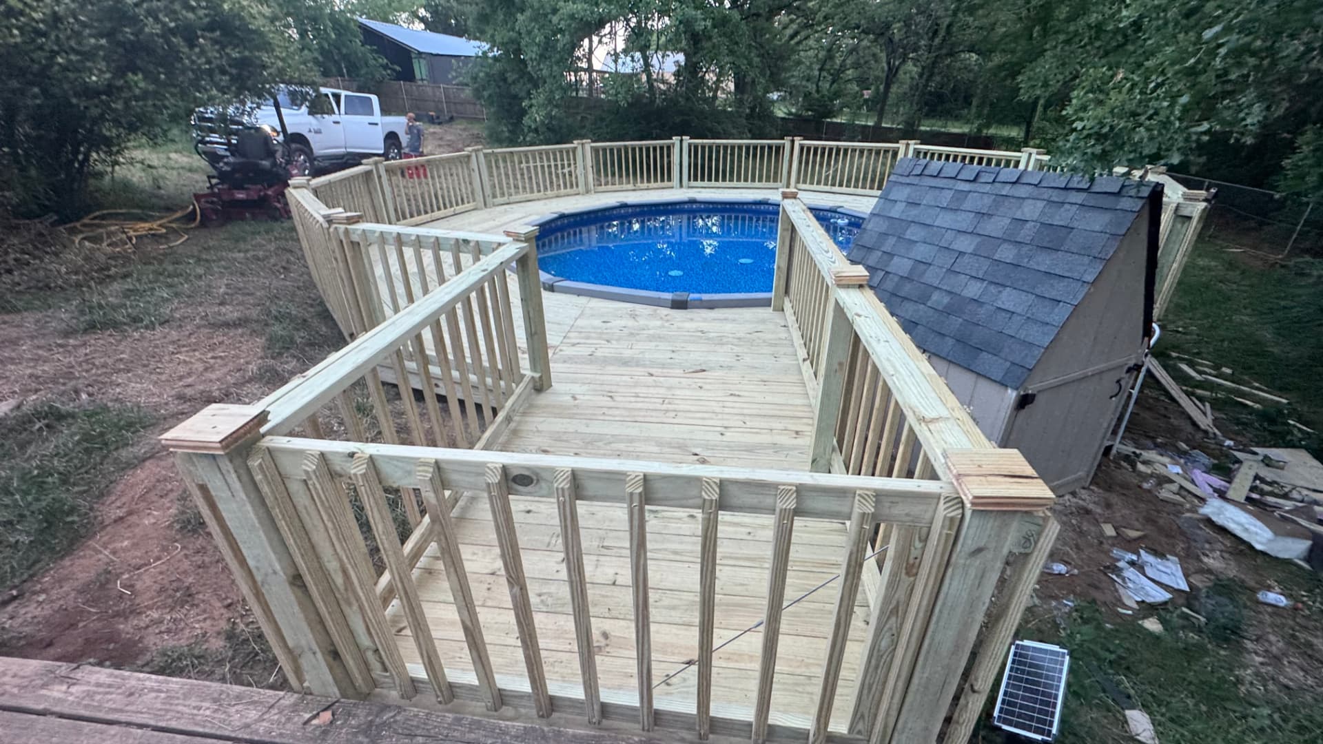 Overhead view of a treated pool deck with gate and shed beside the pool